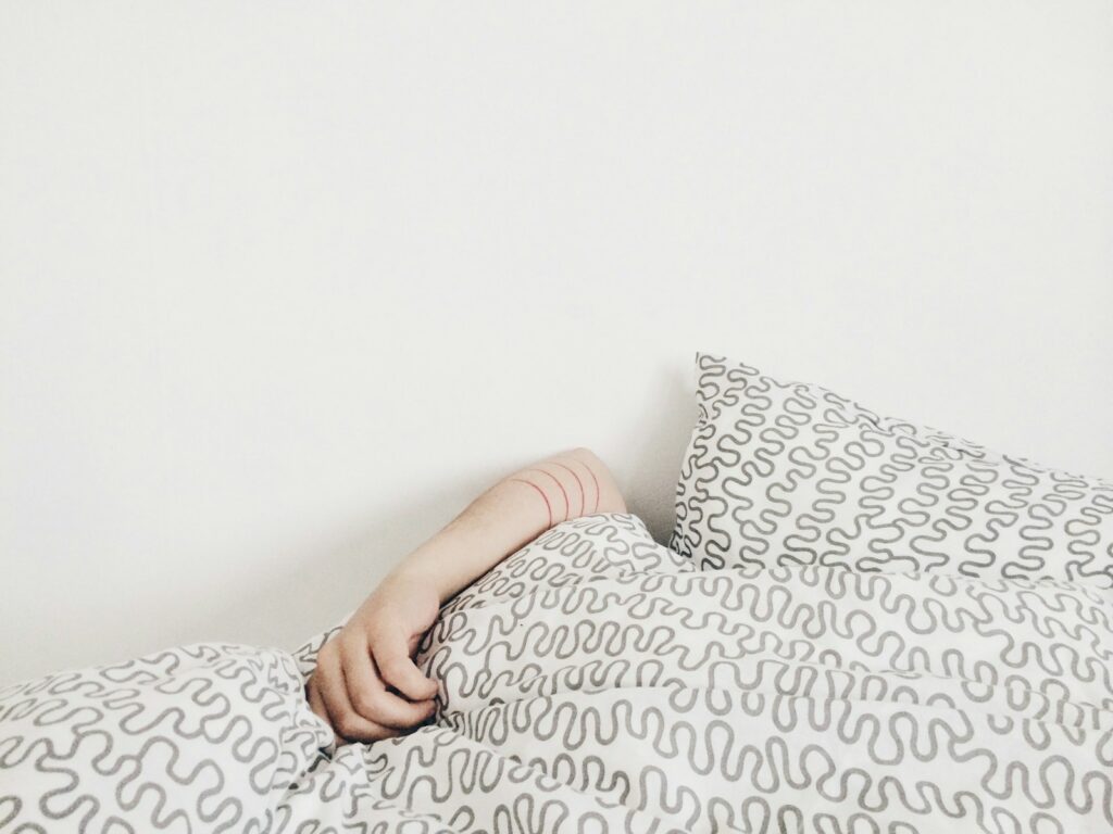 Persona descansando en la cama, ilustrando la relación entre el sueño y el sistema inmunológico.