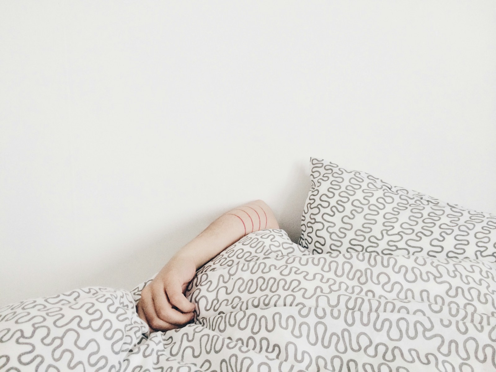 Persona descansando en la cama, ilustrando la relación entre el sueño y el sistema inmunológico.
