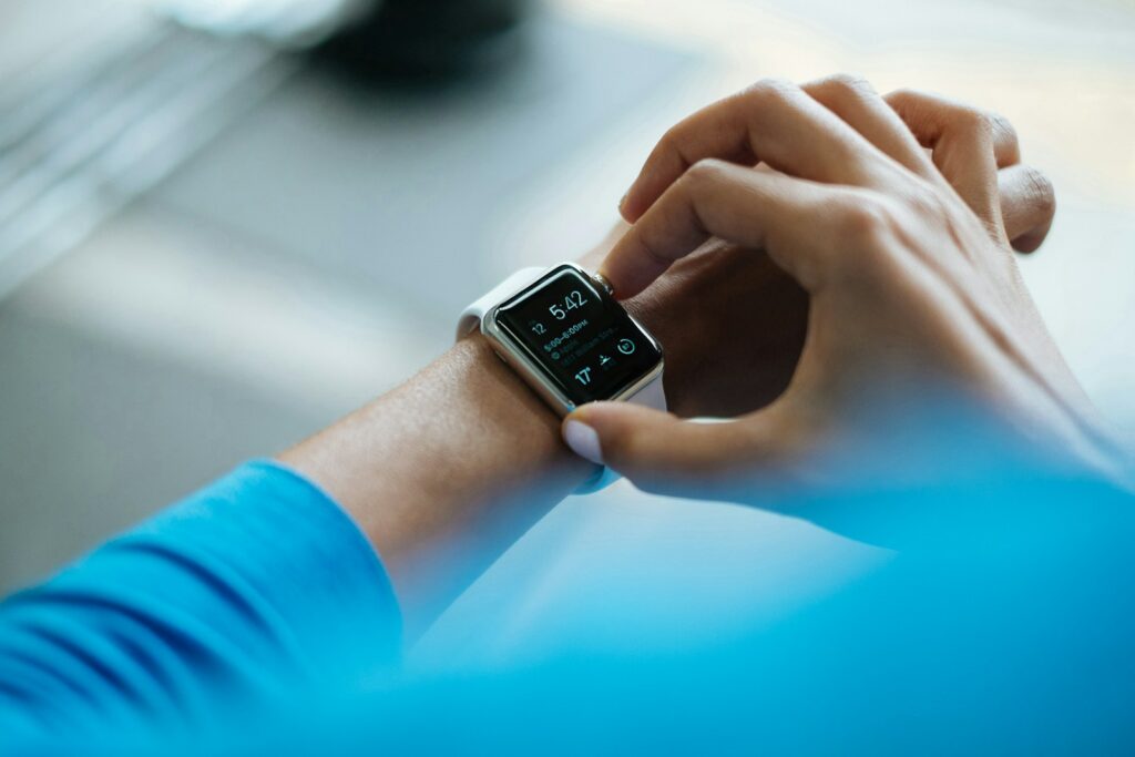 Persona ajustando un smartwatch, ejemplo de tecnología wearable en medicina deportiva.